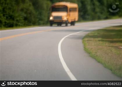 blurry abstract view of school bus driving on road