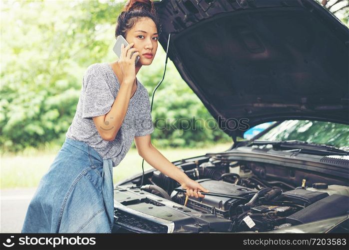 Blurry and soft focus of Asian woman using mobile phone while looking and Stressed man sitting after a car breakdown on street