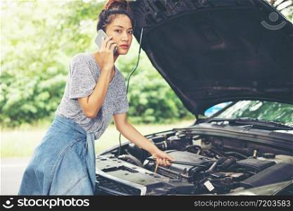 Blurry and soft focus of Asian woman using mobile phone while looking and Stressed man sitting after a car breakdown on street