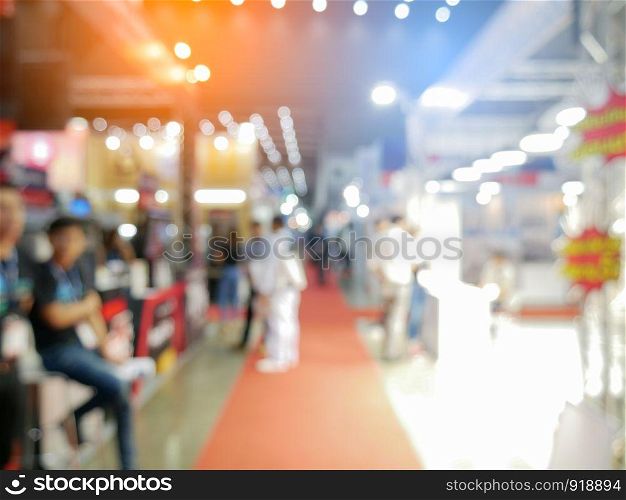 Blurry background of exhibition expo with crowd people in convention hall. Abstract concept. Business marketing and event theme.