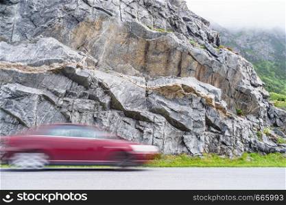 Blurry car driving fast in Norway mountains. Blurried vehicle riding through street in nature.. Blurry car driving fast in mountains