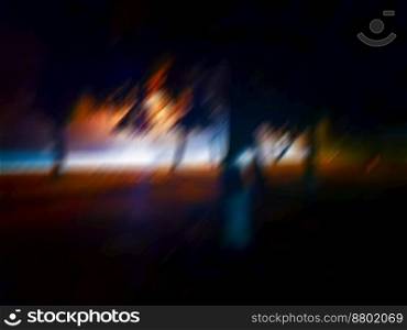 Blurry city skyline at night with defocused buildings. Life at blurred night modern city.. Defocused glowing street at night with lights lanterns