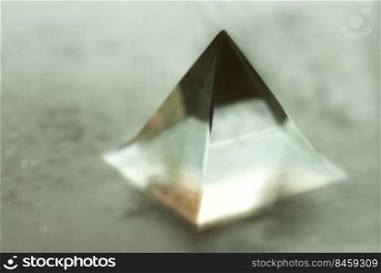 Blurry image of a glass pyramid. Abstract still life image of a geometric object.