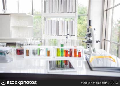 Blurry of microscope and a tablet and Test Tubes, Micropipette and Analysis Results in a laboratory.