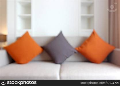 blurry photo, colorful pillows on sofa in living room as background