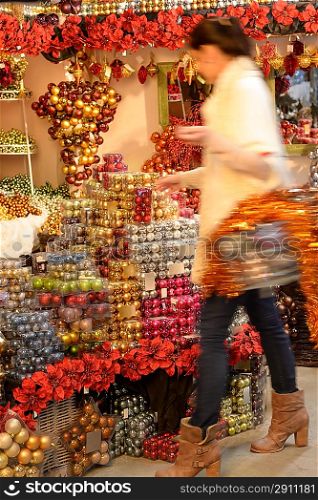Blurry woman buyer shopping Christmas decorations at shop