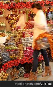 Blurry woman buyer shopping Christmas decorations at shop