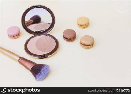 blusher with macaroon makeup brush beige background