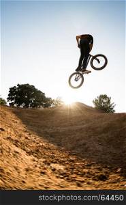 Bmx rider performing a look back at a dirt trail park.