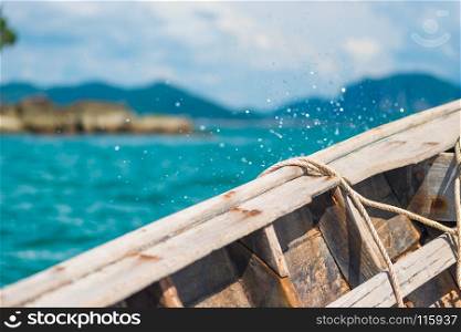 board of a wooden boat close-up and splashing water overboard