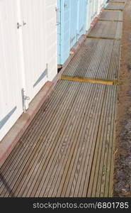 Board walk in front of beach huts. United Kingdom