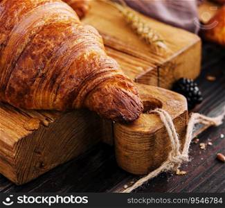Board with tasty croissants and pastries on table
