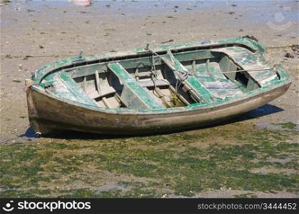 Boat abandoned on the sand at low tide
