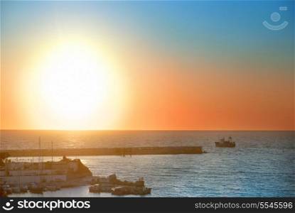 Boat and beautiful colorful sunset above the sea