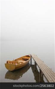 Boat at a landing stage of a lake on a misty morning
