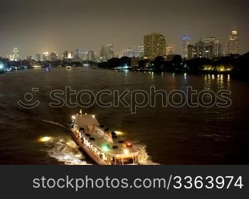 Boat at night on the Chao Phraya River in Bangkok, Thailand.