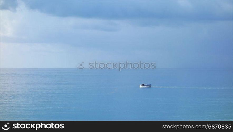 Boat at the sea with rainy clouds