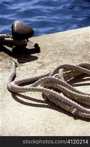 Boat bollard, ropes and knots in mediterranean harbor