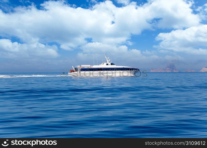 Boat ferry cruising Ibiza to Formentera with Es Vedra in background