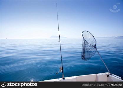 boat fishing rod and landing net in mediterranean blue sea