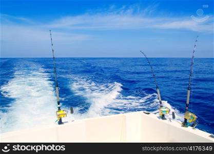 boat fishing trolling in deep blue sea with rods and reels