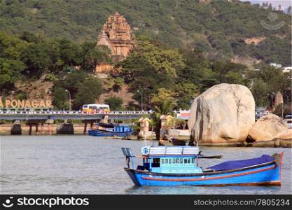 Boat in bay and towers of Ponagar in Nha Trang, Vietnam