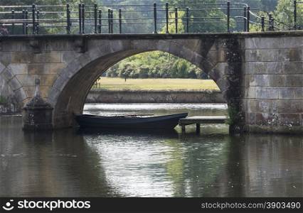 boat int pond under old stone bridge