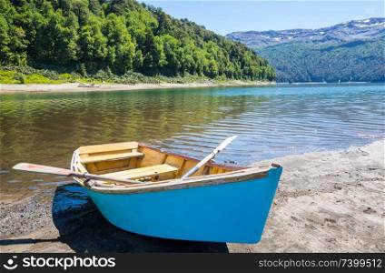 Boat on lake in Chile mountains. Summer season.