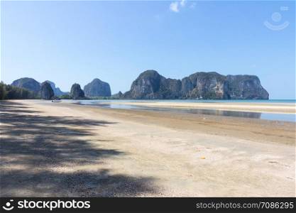 Boat on Rajamangala beach with limestone cliffs in the background,Trang province, Thailand