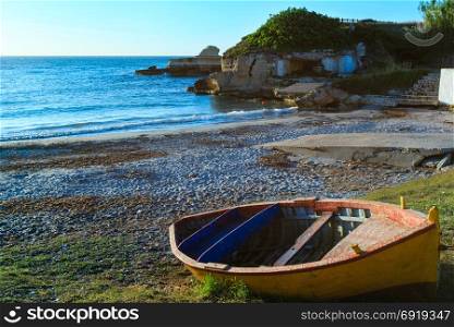 Boat on sunrise Beach Torre Sant&rsquo;Andrea and islet Scoglio the Tafaluro, Otranto region, Salento Adriatic sea coast, Puglia, Italy