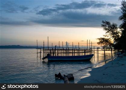 Boat on the shoreline in the tropical place during the sunset.