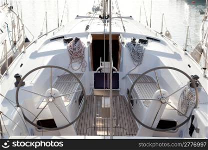 boat stern with double steering wheel and sailboat ropes