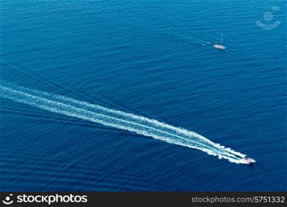 Boat surf foam aerial from prop wash in blue Majorca mediterranean sea