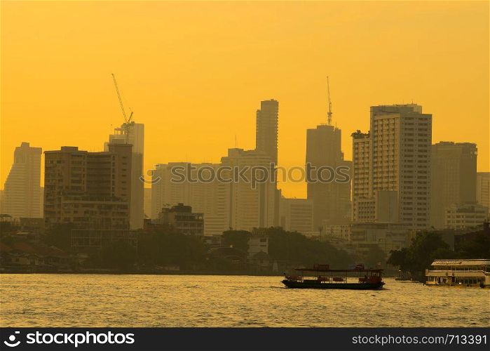 Boat traffic river in evening. Bangkok city and building skyscraper background in sunset.