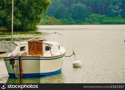 Boat yacht on lake attached to mooring buoy. Tuchola national park in Poland. Yachting, holidays concept.. Yacht on lake in Tuchola Forests, Poland.