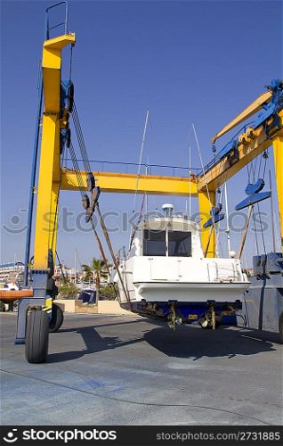 boat yellow crane travelift lifting motorboat for yearly antifouling hull treatment