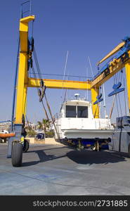 boat yellow crane travelift lifting motorboat for yearly antifouling hull treatment