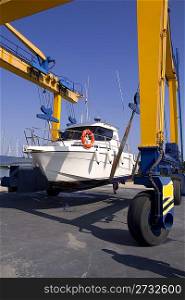 boat yellow crane travelift lifting motorboat for yearly antifouling hull treatment