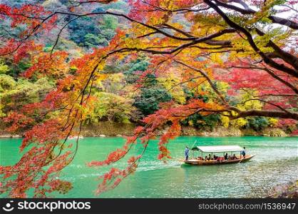 Boatman punting the boat at river. Arashiyama in autumn season along the river in Kyoto, Japan.