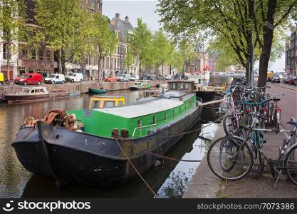 Boats and bikes on Geldersekade canal waterfront in Amsterdam, Holland.