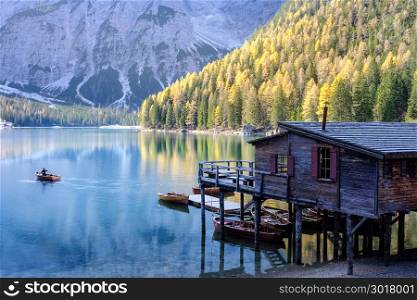 Boats and old house at the alpine mountain lake. Lago di Braies, Dolomites Alps, Italy