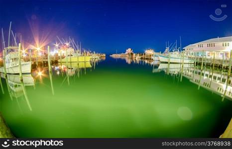 Boats and pier on bay at night