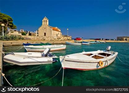 Boats and stone church in Savar, island of Dugi Otok, Croatia