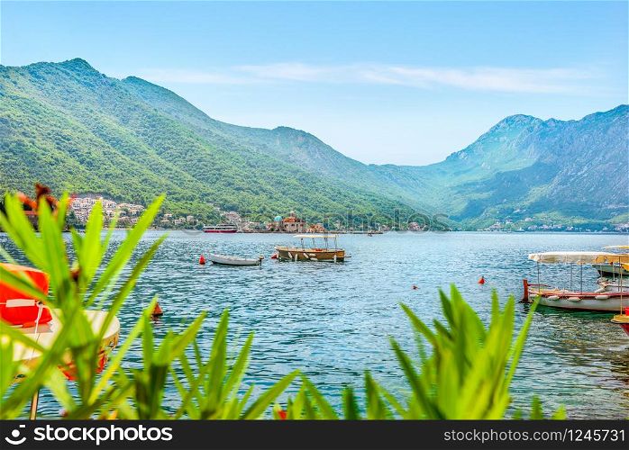 Boats in Adriatic sea with the view on Church of Our Lady and mountains in Perast, Montenegro. Landscape in Perast