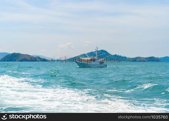 Boats in Patong beach with blue turquoise seawater, Phuket island in summer season during travel holidays vacation trip. Andaman ocean, Thailand. Tourist attraction with blue cloud sky.