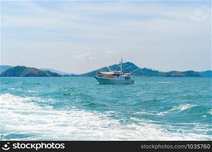 Boats in Patong beach with blue turquoise seawater, Phuket island in summer season during travel holidays vacation trip. Andaman ocean, Thailand. Tourist attraction with blue cloud sky.