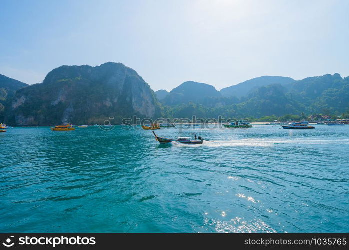 Boats in Patong beach with blue turquoise seawater, Phuket island in summer season during travel holidays vacation trip. Andaman ocean, Thailand. Tourist attraction with blue cloud sky.