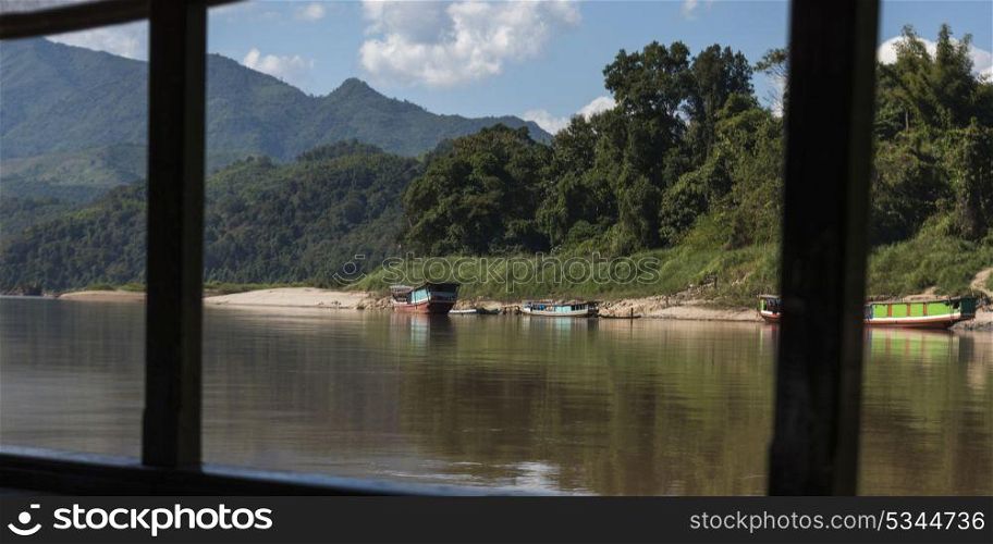 Boats in river seen through from window, River Mekong, Laos