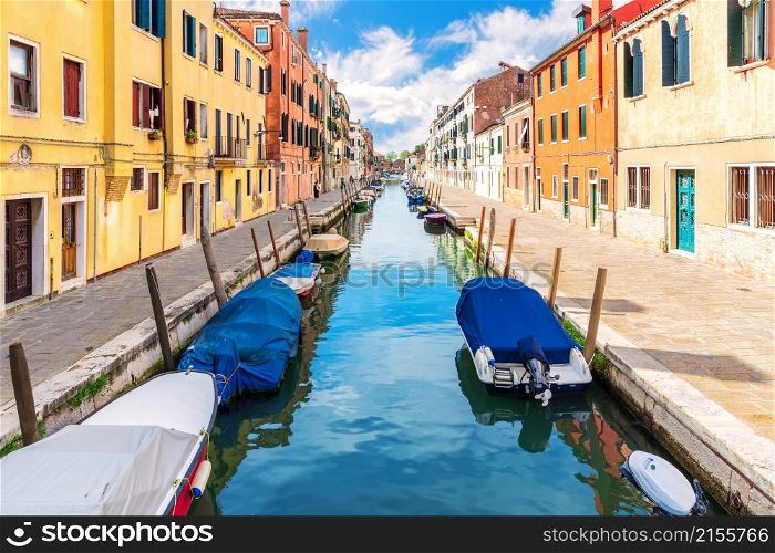 Boats in the canal and bright houses of Venice, Italy.