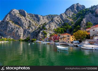 Boats in the fishing harbor at the mouth of the river. Omis. Croatia.. Omis. Old fishing harbor on a sunny day.